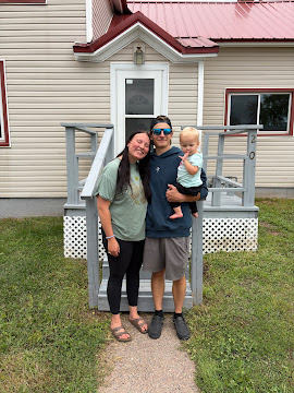 A family standing on the front steps of a home